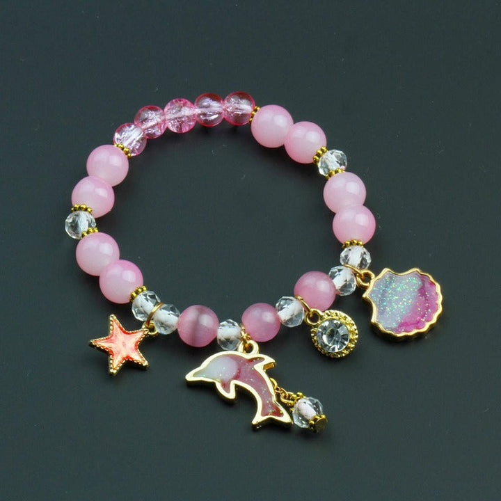 Bracelet en perles avec un charme dauphin et un coquillage
