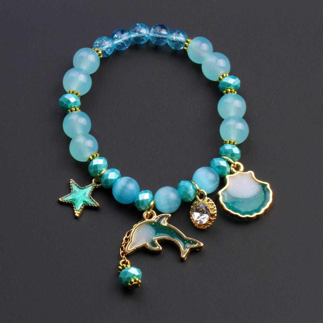 Bracelet en perles avec un charme dauphin et un coquillage