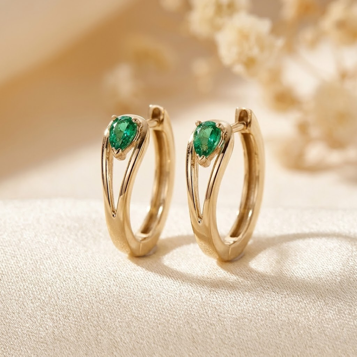 Gold hoop earrings with emerald accents