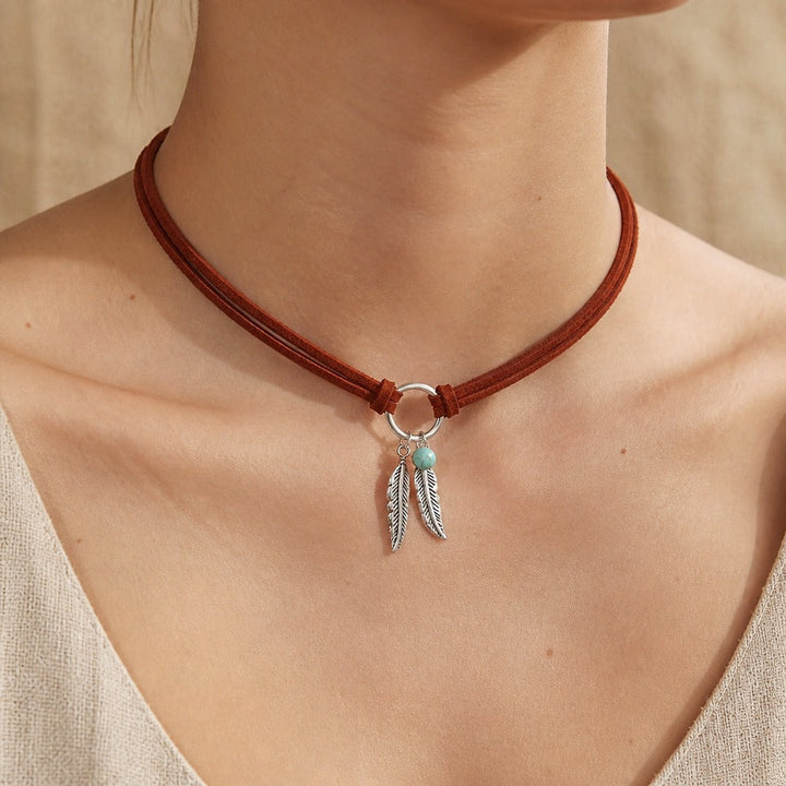 Collier choker avec pendentif en plume et perles